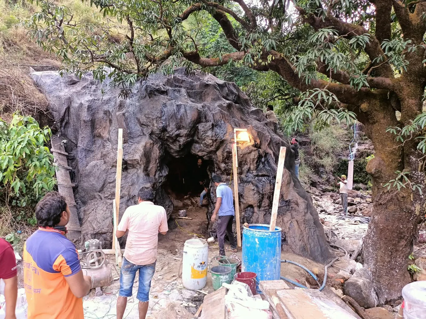 Crew carving a film set into raw rock inside a Sahyadri cave